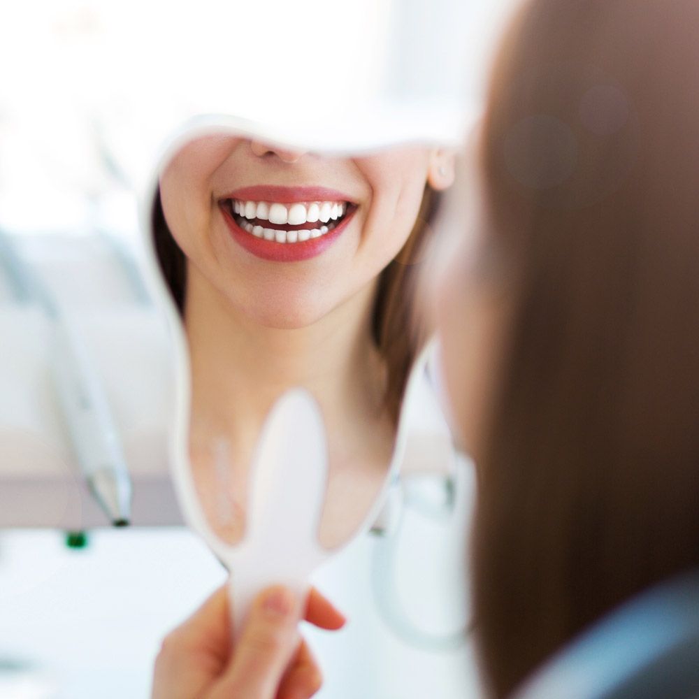 woman smiling into mirror